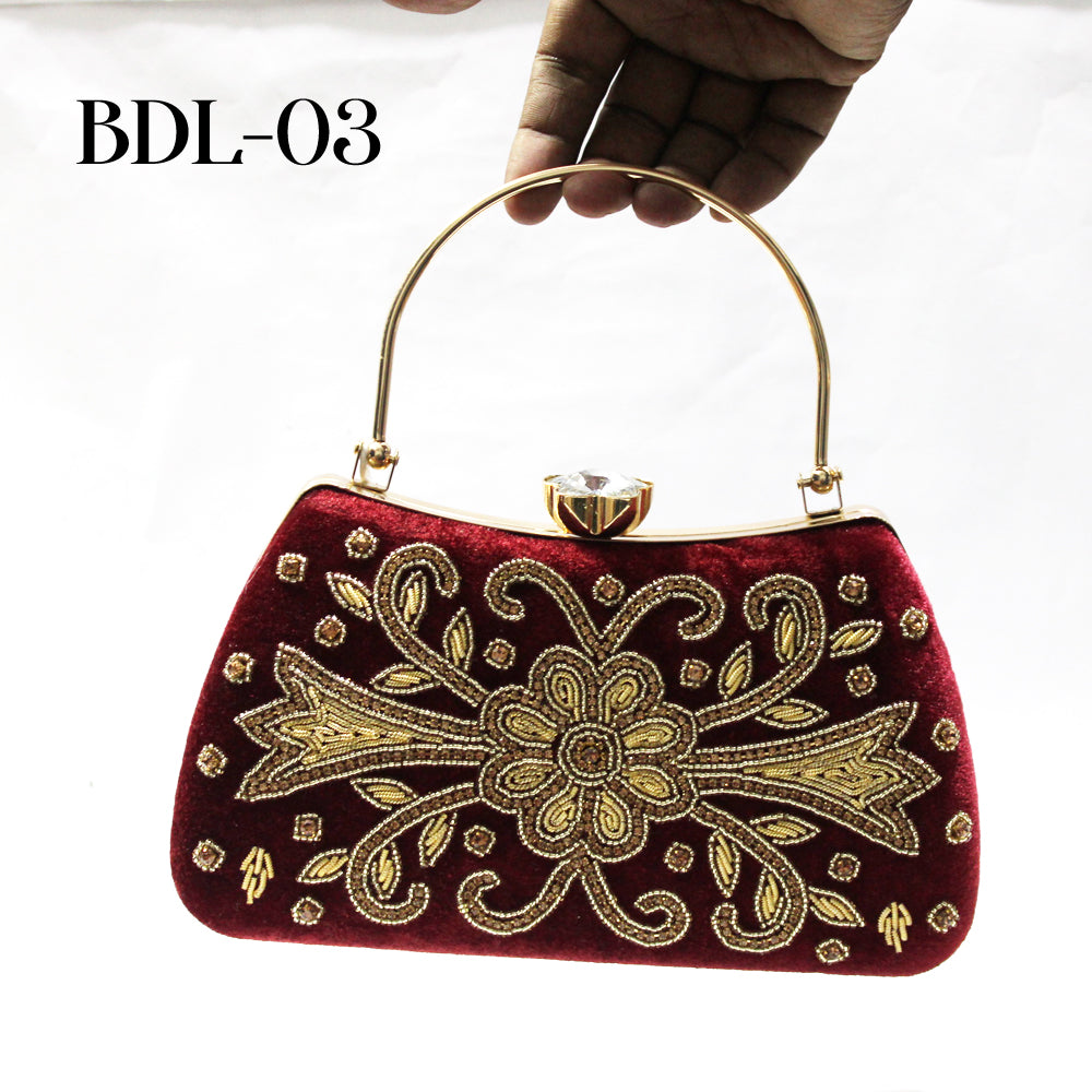 Red handbag with gold embroidery held by a hand on a white background