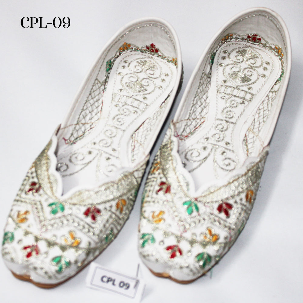 Pair of white embroidered shoes with colorful details on a white background