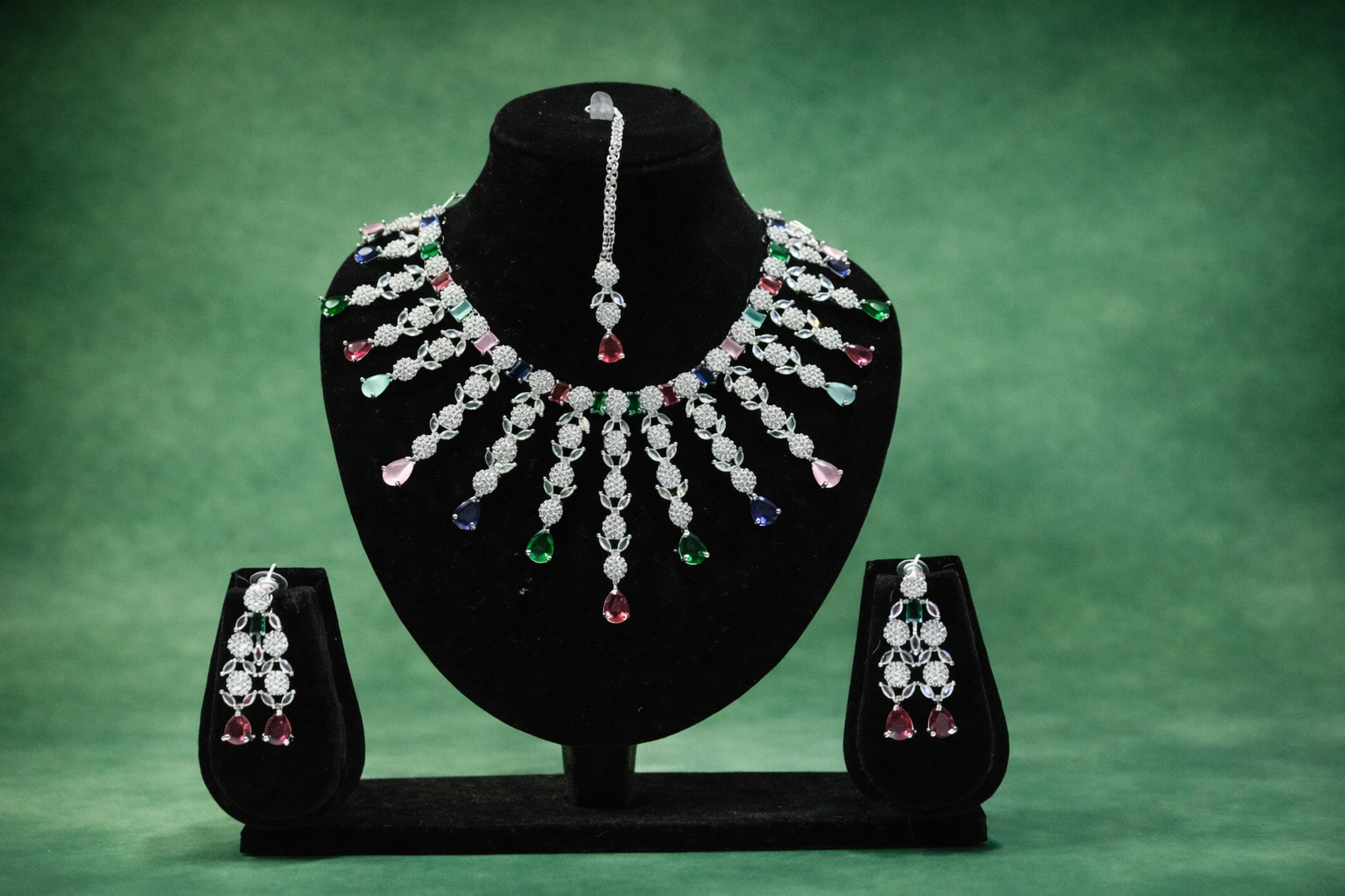 Jewelry set with necklace and earrings on a green background