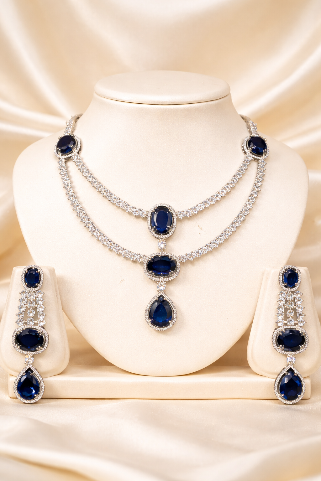 Jewelry set with necklace and earrings featuring blue gemstones on a beige background