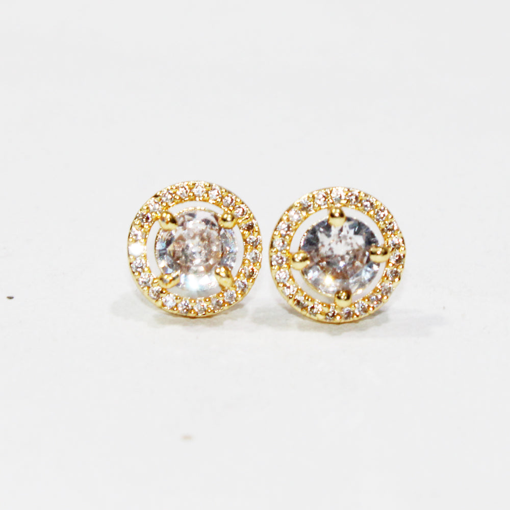 Pair of gold earrings with clear gemstones on a white background