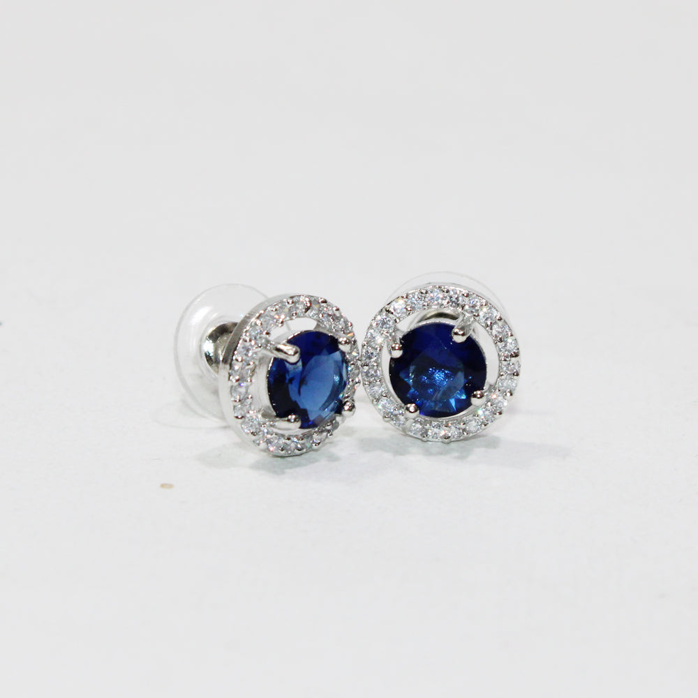 Pair of silver earrings with blue gemstones on a white background