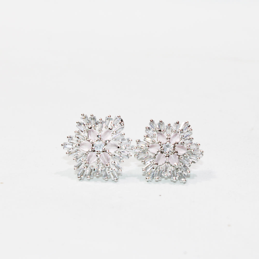 Pair of silver floral earrings on a light gray background
