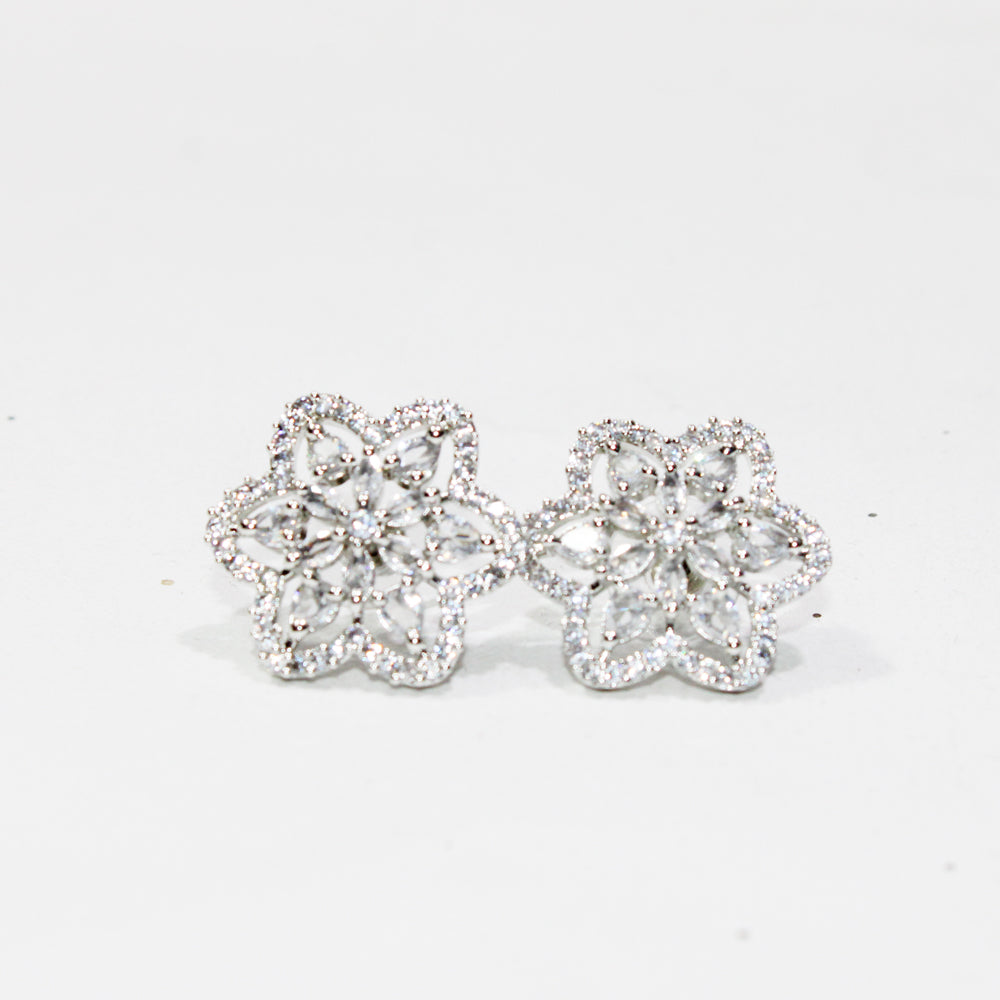 Pair of silver floral earrings on a light gray background