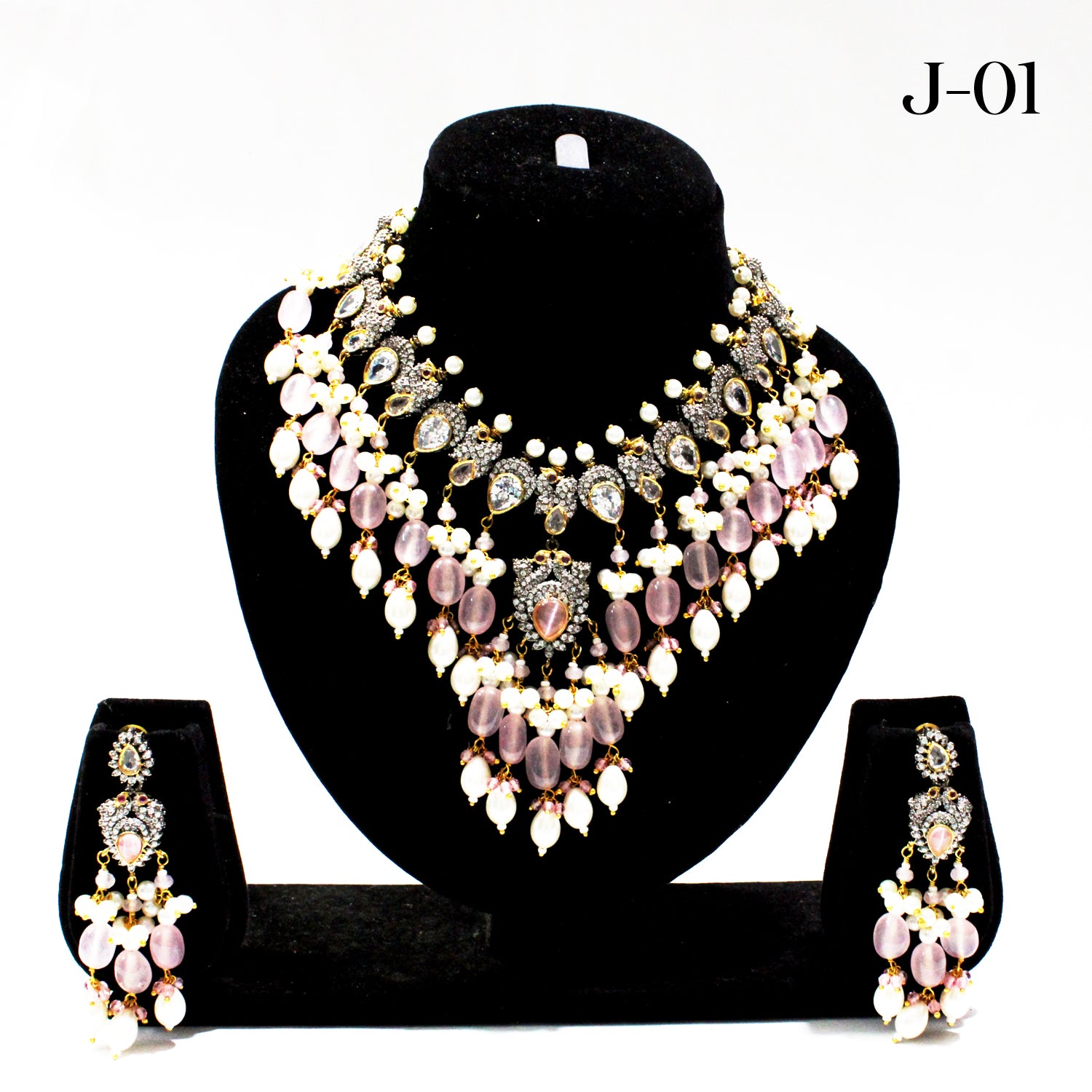 Jewelry set with necklace and earrings on a black stand against a white background