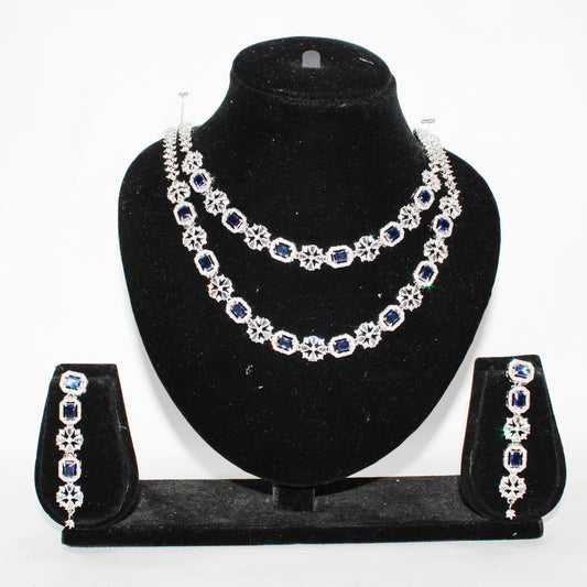 Jewelry set with necklace, earrings, and bracelet on a black stand against a white background