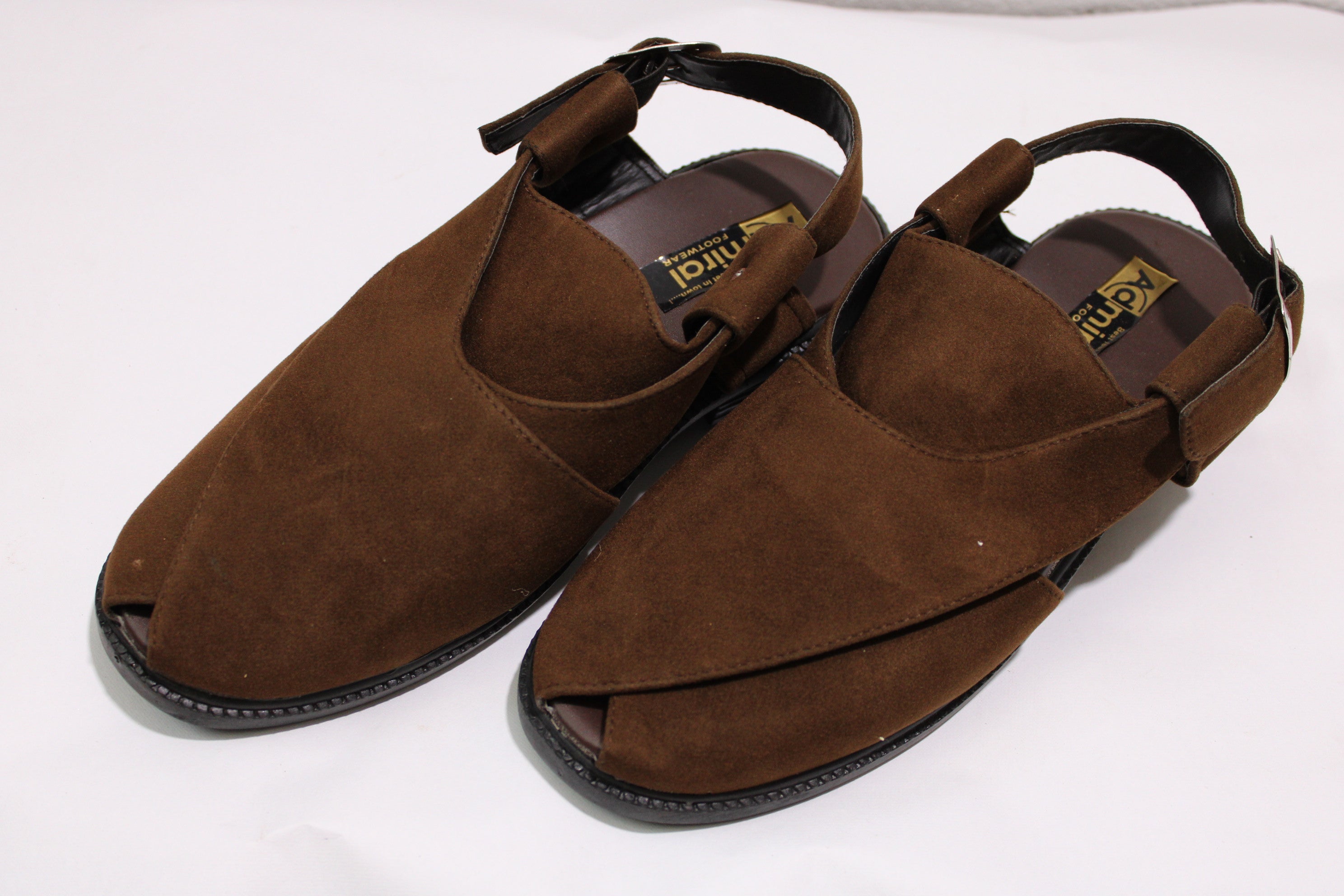 Pair of brown suede sandals on a white background