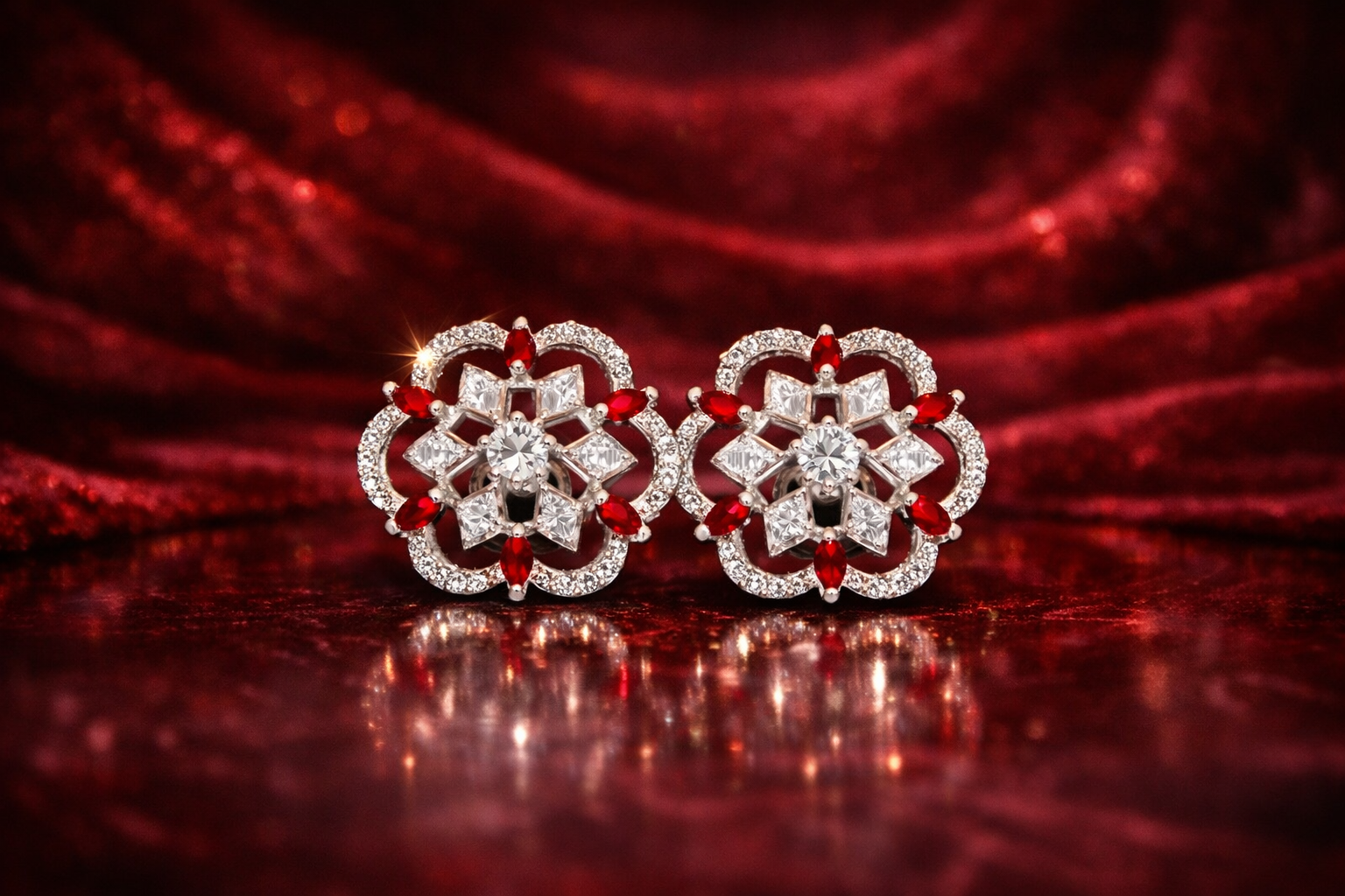 Pair of diamond earrings with red accents on a red fabric background