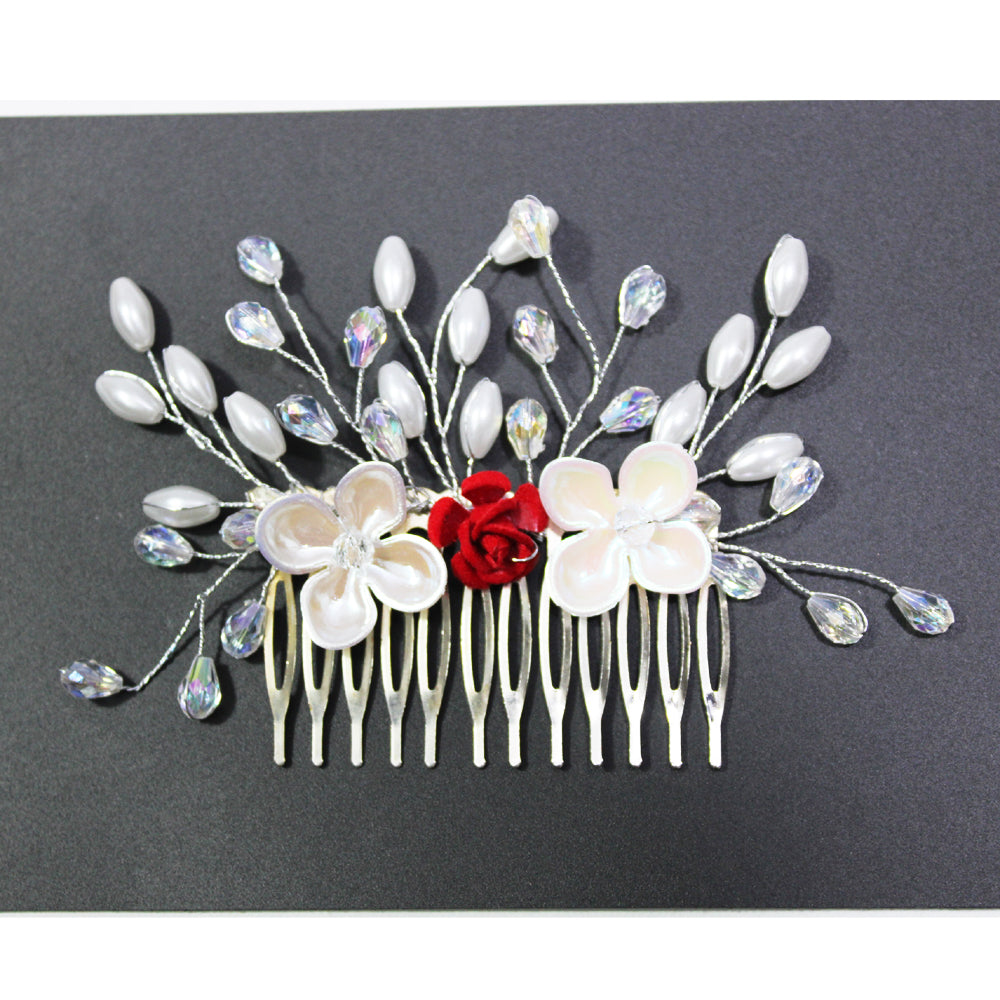 Decorative hair comb with flowers and beads on a dark background