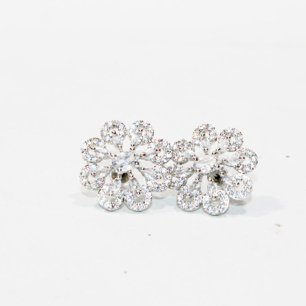 Pair of silver floral earrings with clear gemstones on a white background