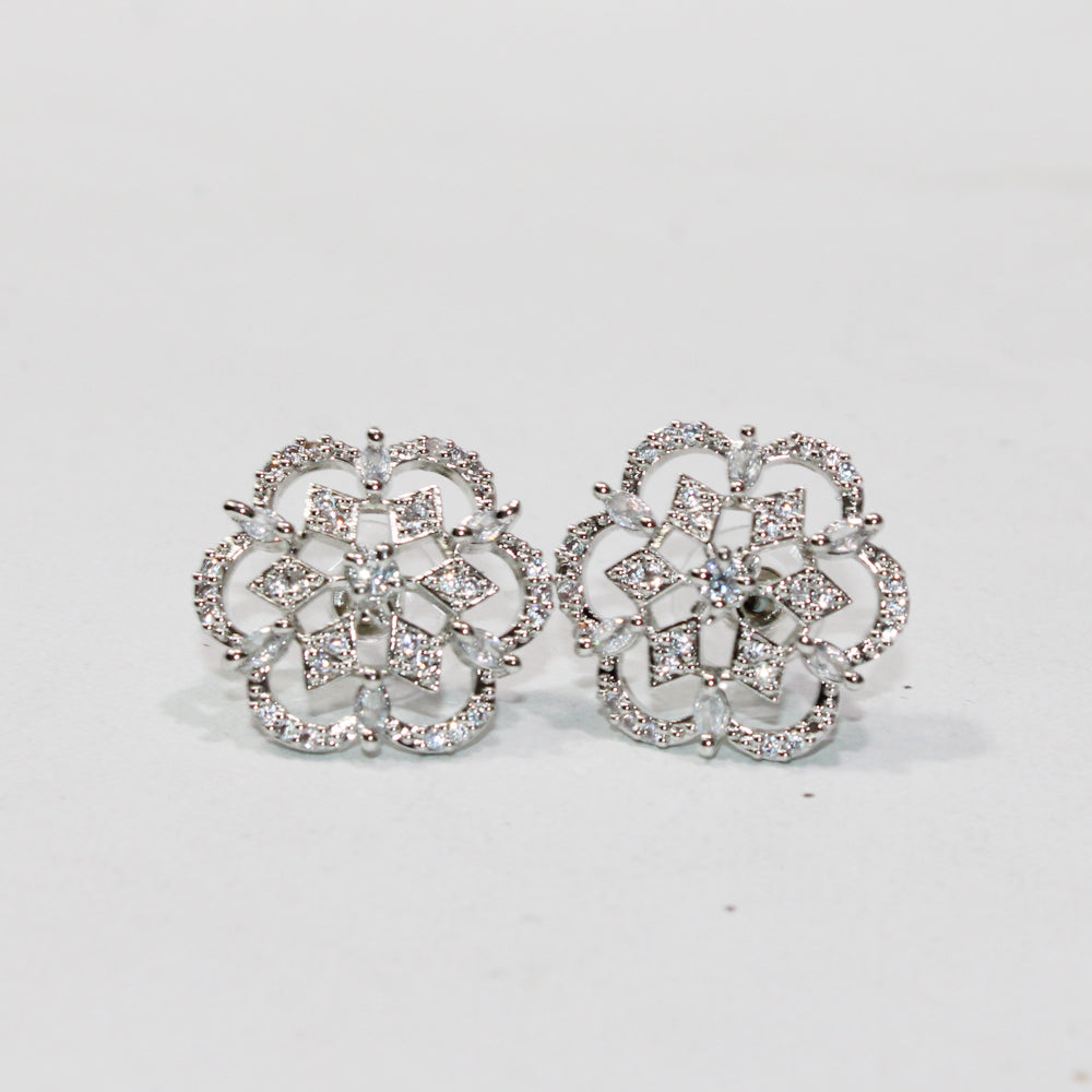Pair of silver floral earrings on a light gray background
