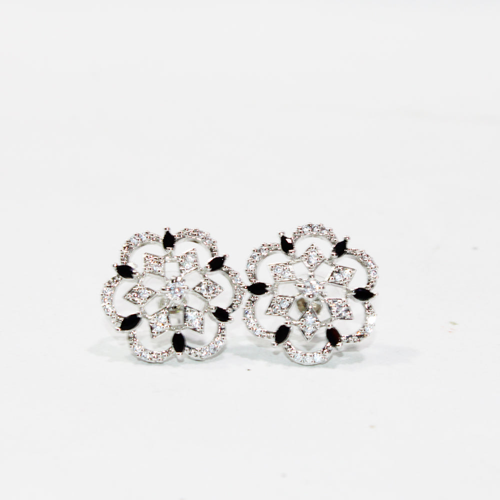Pair of ornate earrings with black accents on a light gray background