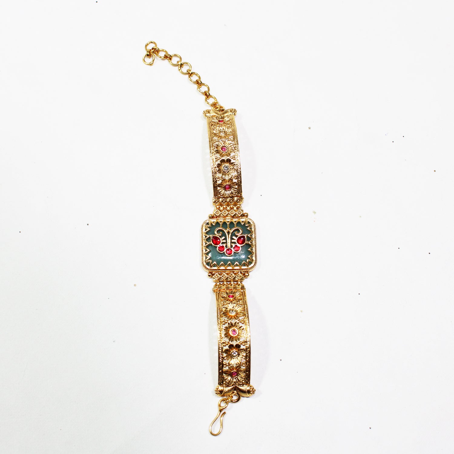 Decorative gold bracelet with gemstones on a white background